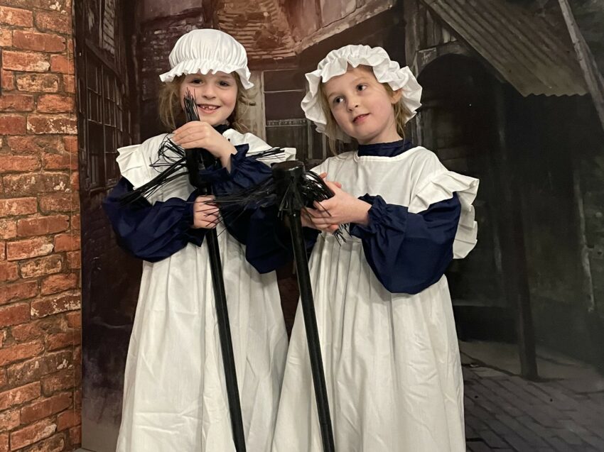 Two children stood in Victorian outfits